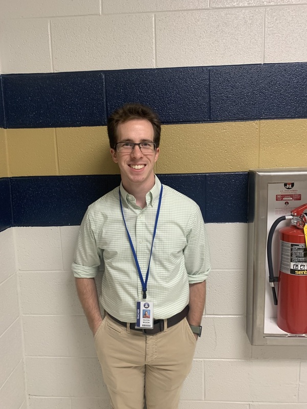 Mr. Wilson poses in front of his classroom.