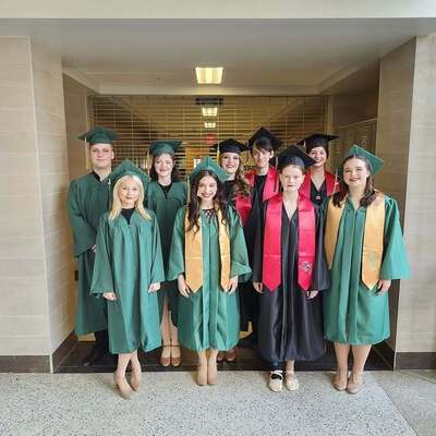 The seniors in the Burton Performing Arts Program pose in graduation attire before the show